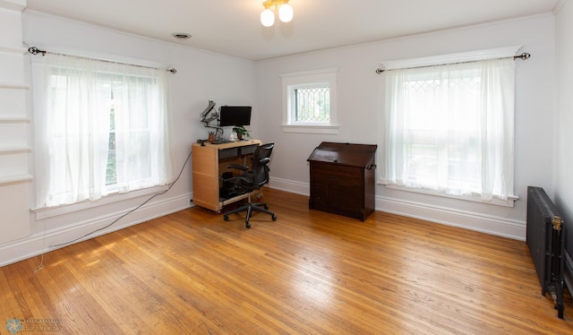 office with light hardwood / wood-style floors and radiator