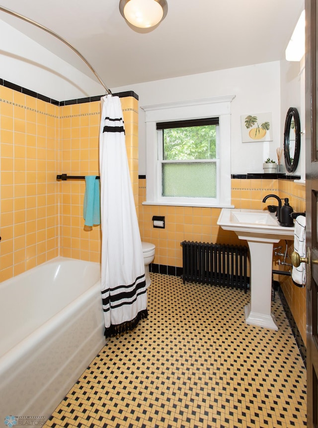 full bathroom with shower / bath combination with curtain, toilet, radiator, and tile walls