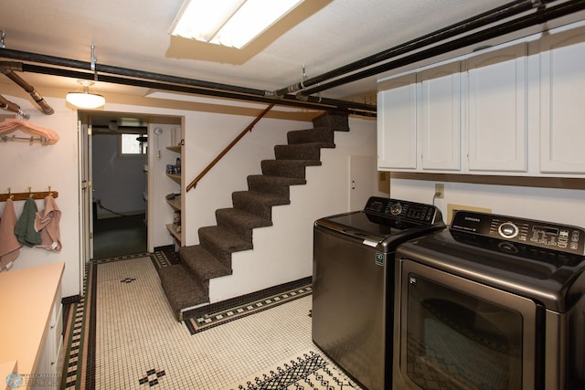 laundry room featuring cabinets, separate washer and dryer, and light tile patterned floors