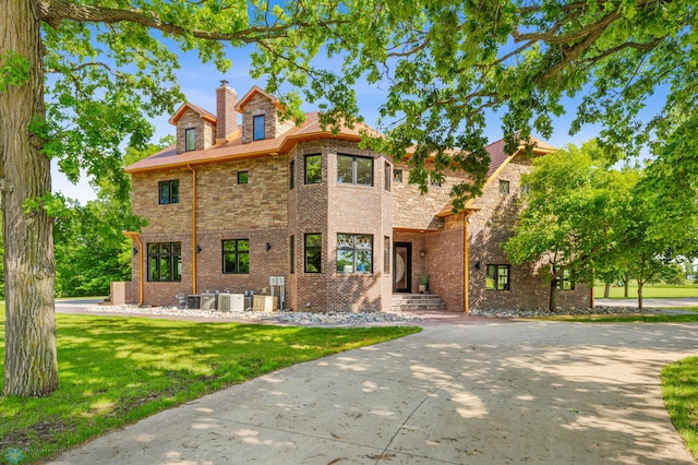 view of front of property with a front yard and central AC unit