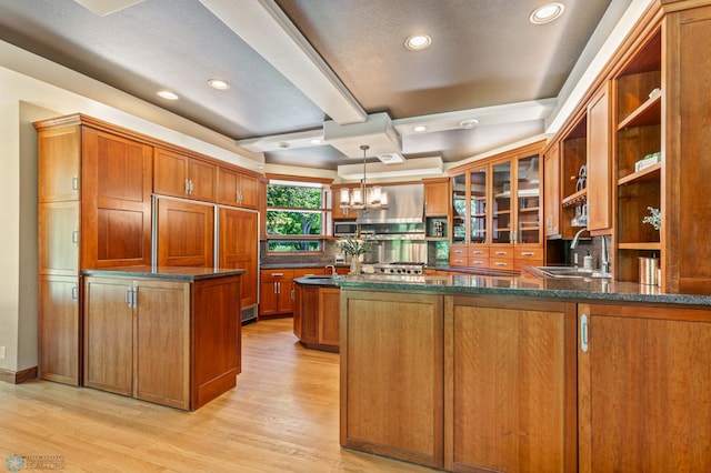 kitchen featuring sink, hanging light fixtures, kitchen peninsula, and light hardwood / wood-style flooring