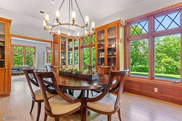 dining room with a notable chandelier, light hardwood / wood-style floors, and a healthy amount of sunlight