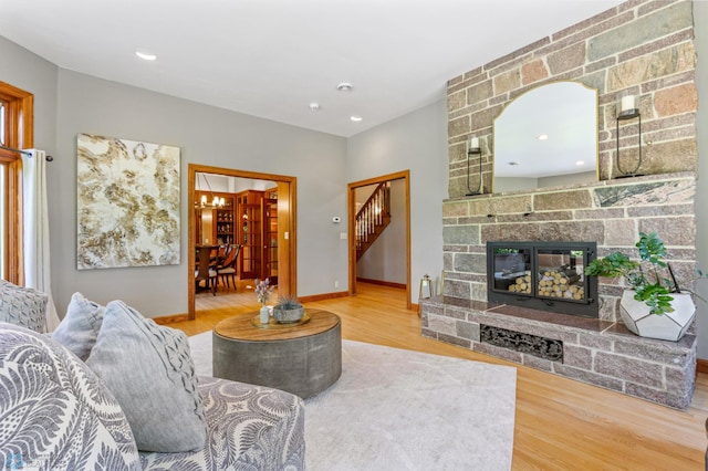 living room with a stone fireplace and hardwood / wood-style flooring