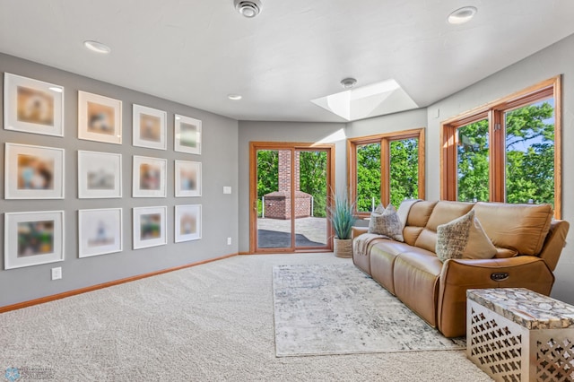 carpeted living room with plenty of natural light and a skylight