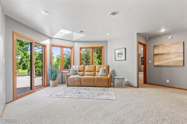 living room with carpet floors and a skylight