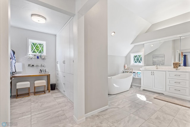 bathroom featuring a healthy amount of sunlight, tile flooring, vanity, and lofted ceiling