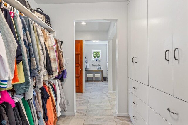 walk in closet featuring light tile flooring