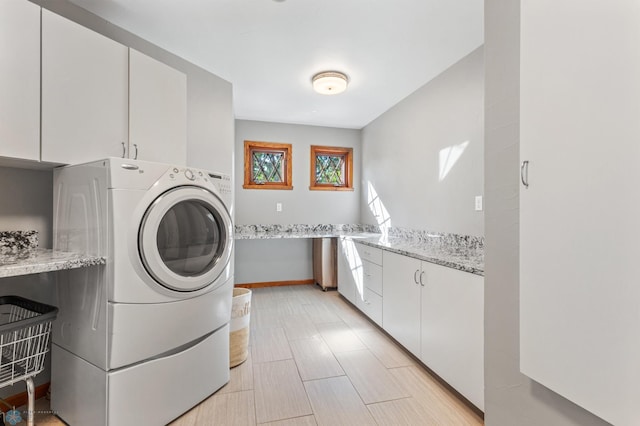 laundry room with cabinets and washer / dryer