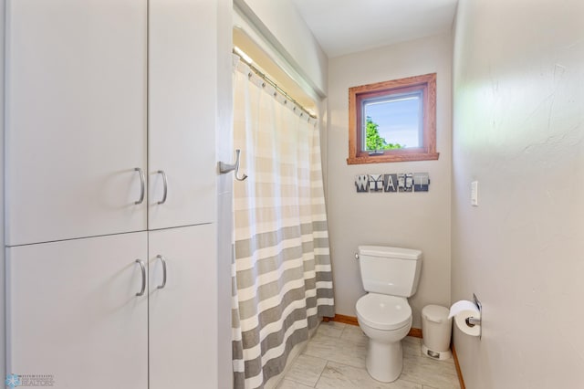 bathroom with tile flooring and toilet