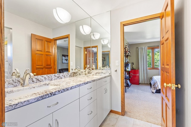 bathroom featuring tile flooring, oversized vanity, and dual sinks