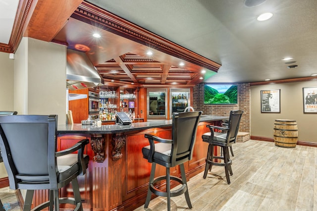 bar with beam ceiling, light hardwood / wood-style floors, ornamental molding, and coffered ceiling