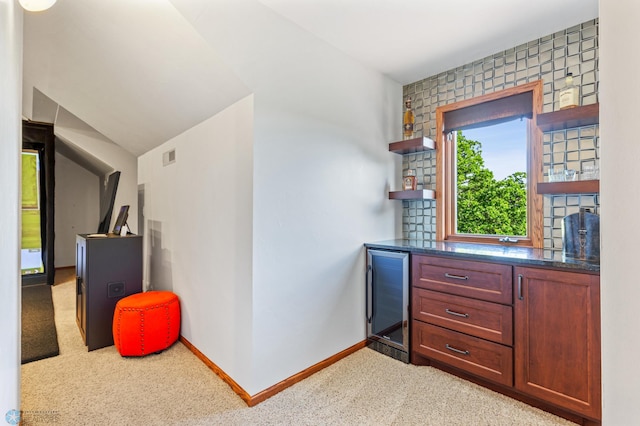 bar with carpet, beverage cooler, and lofted ceiling