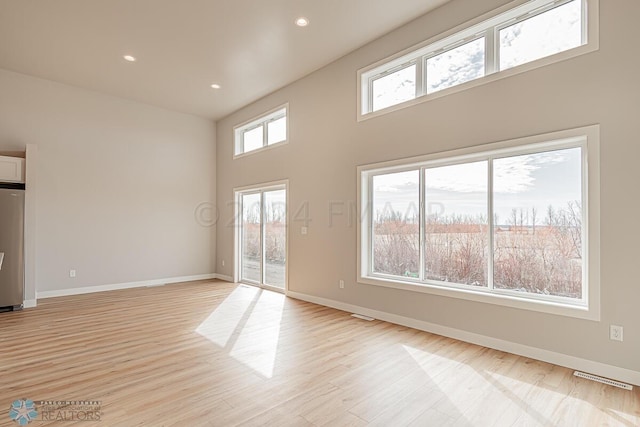 interior space featuring light hardwood / wood-style flooring and a high ceiling