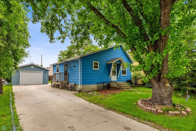 view of front of home with a front yard, a garage, and an outdoor structure