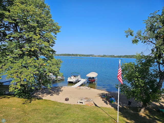 view of dock featuring a water view and a yard