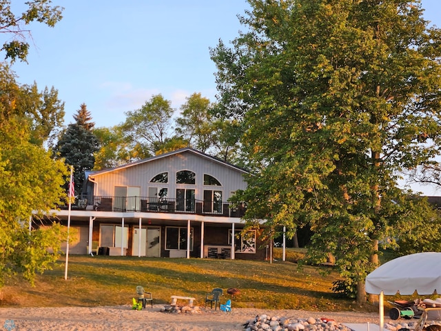 back of house featuring a wooden deck and a yard