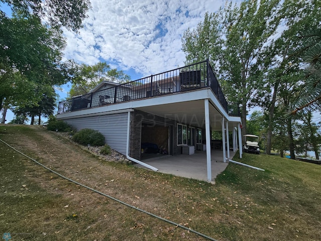 back of property with a lawn and a patio area