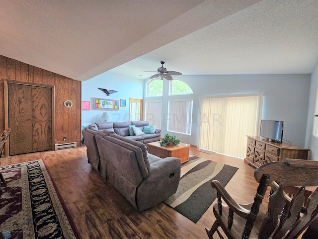 living room featuring vaulted ceiling, a baseboard heating unit, wooden walls, and light wood-type flooring