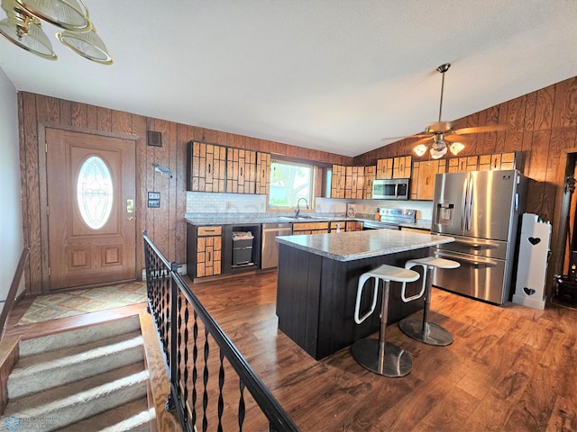 kitchen featuring light wood-type flooring, appliances with stainless steel finishes, a healthy amount of sunlight, and vaulted ceiling