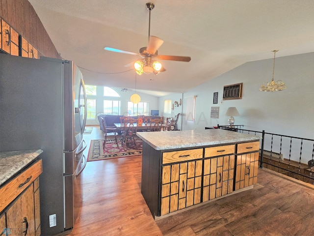 kitchen featuring lofted ceiling, a center island, ceiling fan with notable chandelier, dark hardwood / wood-style flooring, and stainless steel refrigerator with ice dispenser