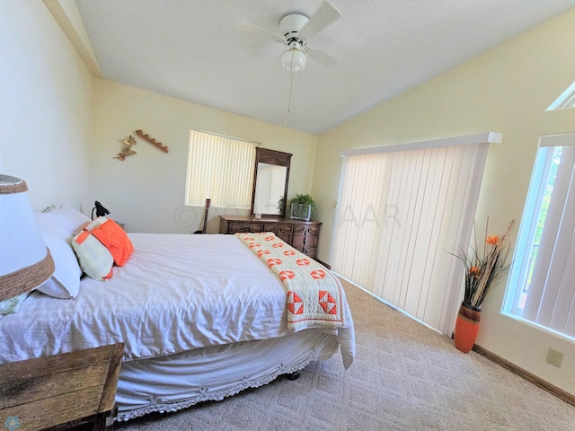 bedroom featuring vaulted ceiling, light colored carpet, and ceiling fan