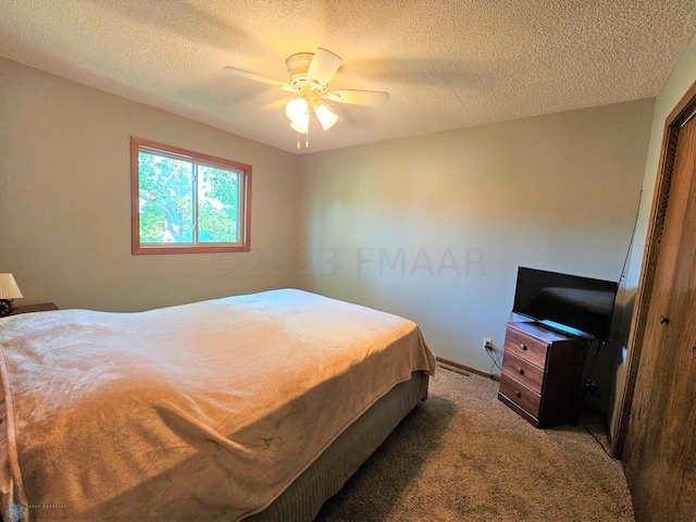 carpeted bedroom with a textured ceiling, a closet, and ceiling fan