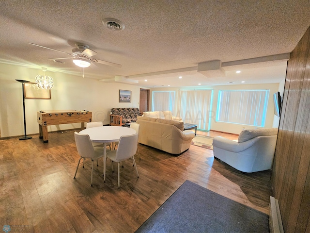 dining room featuring a textured ceiling, wood-type flooring, and ceiling fan with notable chandelier