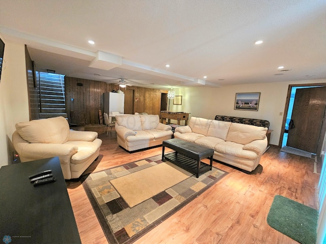 living room featuring ceiling fan and light hardwood / wood-style flooring