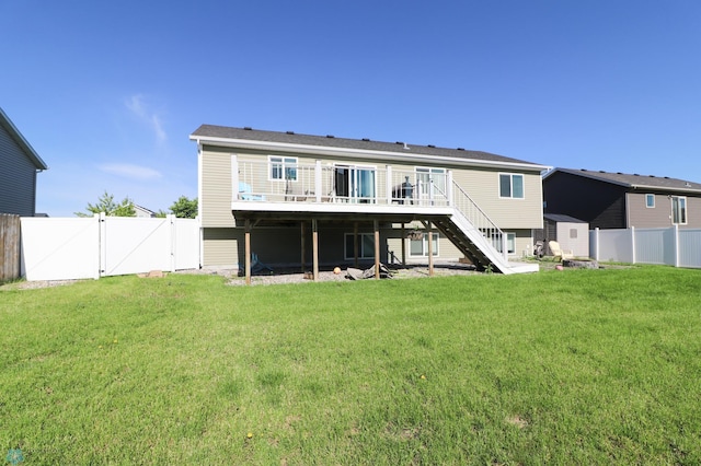 rear view of property featuring a lawn and a wooden deck