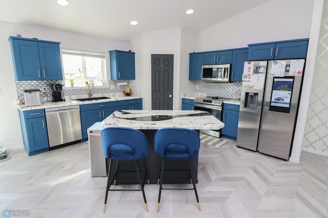 kitchen featuring lofted ceiling, a kitchen island, appliances with stainless steel finishes, a breakfast bar area, and light parquet flooring