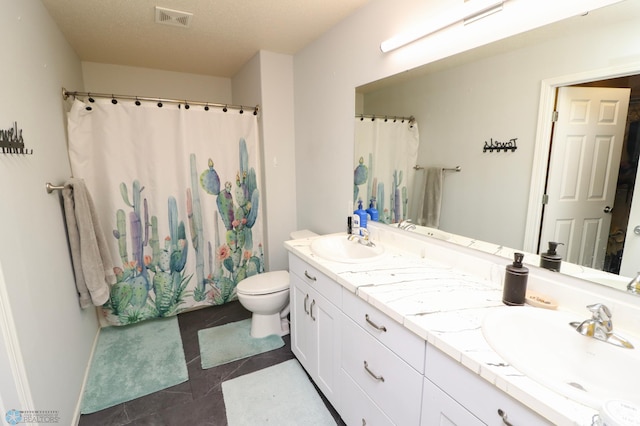 bathroom featuring double sink vanity, tile flooring, a textured ceiling, and toilet