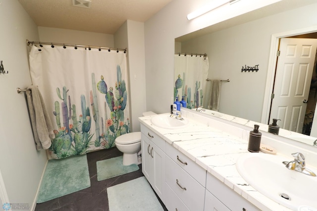 bathroom featuring dual vanity, tile flooring, a textured ceiling, and toilet