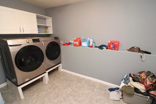 laundry room with washing machine and dryer and cabinets