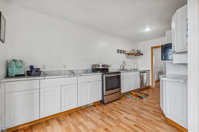 kitchen with sink, stainless steel appliances, light hardwood / wood-style floors, and white cabinetry