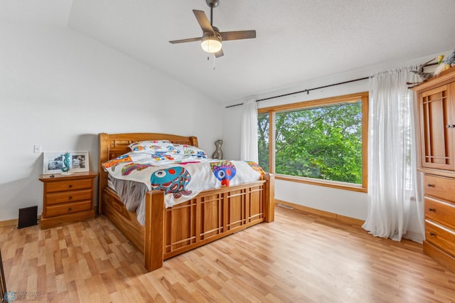 bedroom with ceiling fan, lofted ceiling, and light wood-type flooring