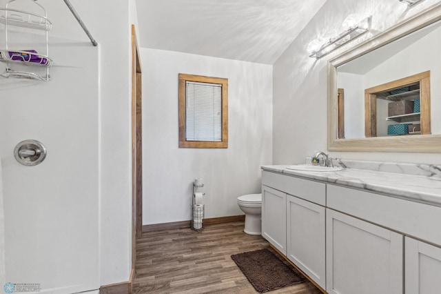 bathroom with hardwood / wood-style flooring, oversized vanity, and toilet