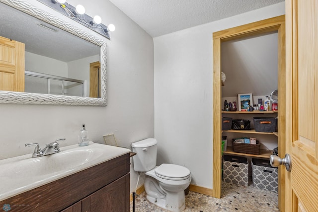 bathroom featuring tile floors, a textured ceiling, vanity, and toilet