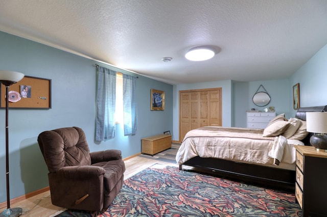 bedroom with a closet, a textured ceiling, and wood-type flooring