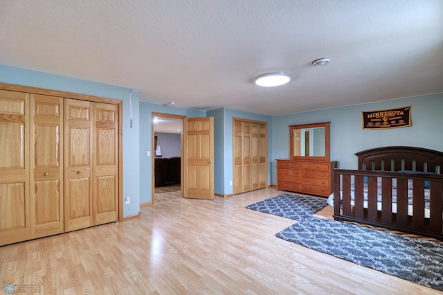 bedroom with a textured ceiling and light wood-type flooring