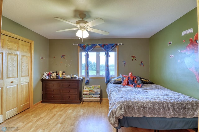 bedroom with a closet, light wood-type flooring, and ceiling fan