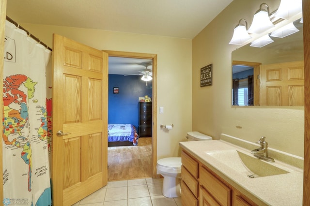 bathroom featuring ceiling fan, tile flooring, toilet, and vanity