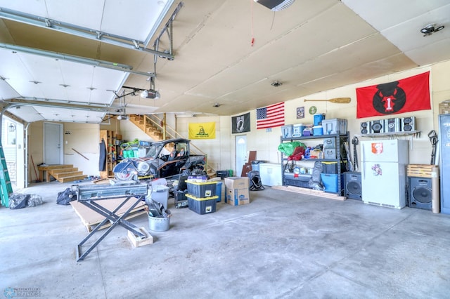 garage featuring white refrigerator and a garage door opener