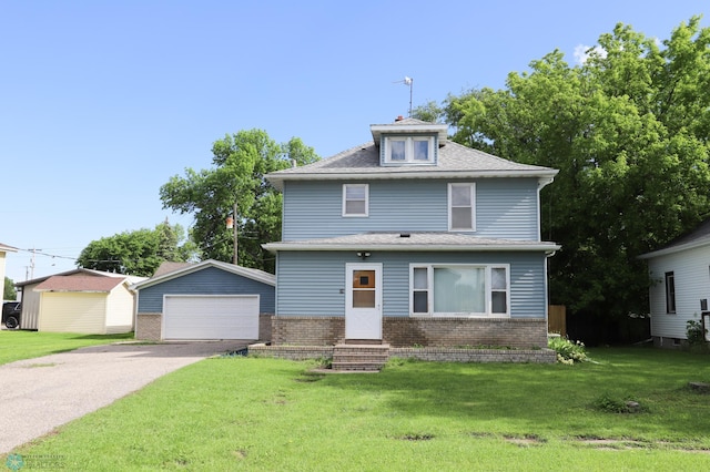 view of front facade featuring a front lawn, a garage, and an outdoor structure