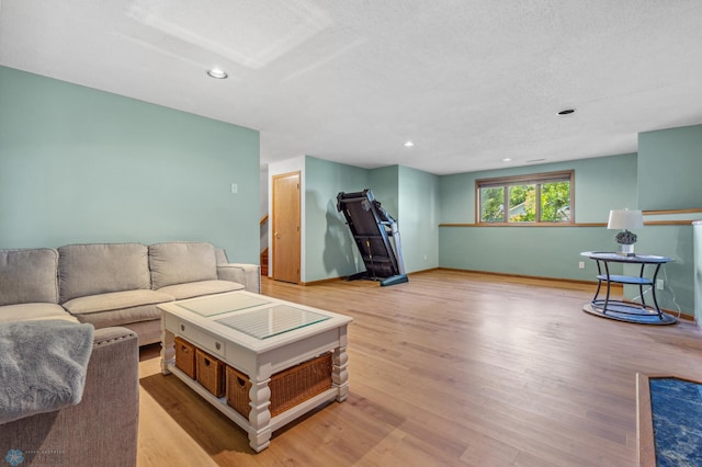 living room with wood-type flooring and a textured ceiling