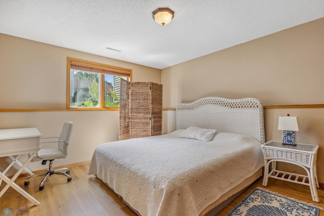 bedroom featuring hardwood / wood-style floors and a textured ceiling