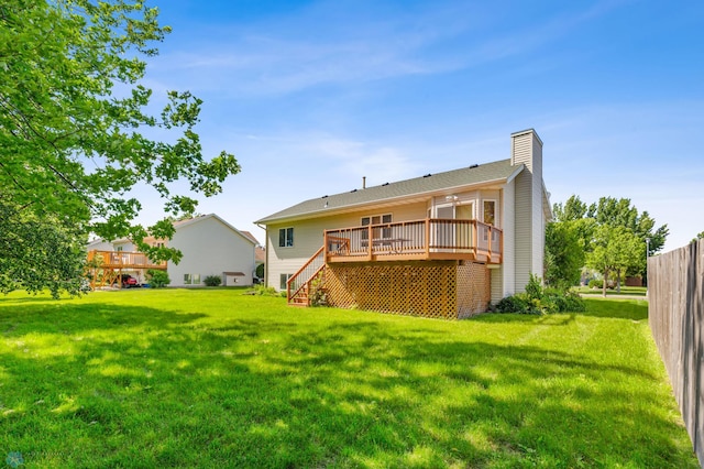 back of house with a deck and a lawn