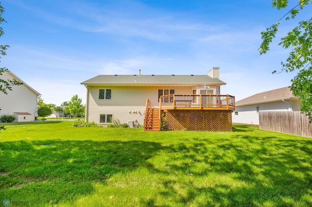 back of property with a yard and a deck