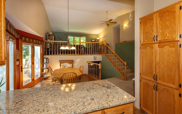 kitchen featuring ceiling fan, carpet flooring, high vaulted ceiling, and light stone countertops