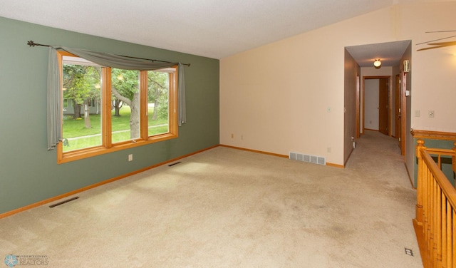 unfurnished room with vaulted ceiling and light carpet