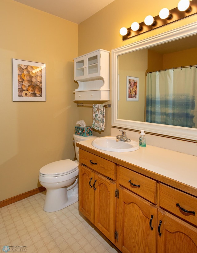 bathroom with toilet, tile patterned floors, and vanity